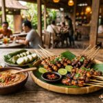 Best Restaurants in Java Island: Complete 2025 Eating Guide A wide, inviting shot of a beautifully presented Indonesian satay platter with various condiments and a refreshing drink, set on a restaurant table with a blurred background suggesting a lively dining atmosphere in Java.