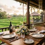 Best Restaurants in Ubud: 7 Must-Try Places to Eat (2025) A wide, inviting shot of a beautifully set table at an open-air restaurant in Ubud, Bali, with lush green rice paddies and tropical foliage in the background, suggesting a serene dining experience.