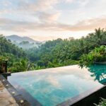 10 Best Hotels in Ubud: Top 5 Luxury Stays for 2025 A serene, luxurious infinity pool overlooking a lush, tropical jungle valley in Ubud, Bali, with sunlight filtering through the trees.