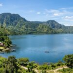 Top 5 Hotels in Lake Toba (2025): Best Stays by Indonesia's Lake Wide view of Lake Toba with lush green hills and a traditional Batak house by the shore.