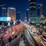 Jakarta Nightlife 2025: Top 5 Bars, Clubs & After-Dark Highlights A busy street scene in Jakarta at night, with blurred car lights and illuminated buildings.