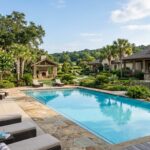 12 Best Spa Resorts In The South (2025 Guide) | Travel & Hotels Expert A serene outdoor spa area at a luxurious resort in the Southern United States, with a swimming pool and lush landscaping.