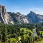 15 Best Hotels in Yosemite National Park (2025 Guide) A wide view of Yosemite Valley with Half Dome and El Capitan under a clear sky.