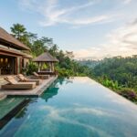A luxurious private villa with an infinity pool overlooking a lush jungle in Ubud, Bali.