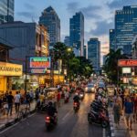 A brightly lit street scene in Jakarta at dusk, with various restaurants and cafes.