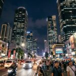 Jakarta Nightlife 2025: Top 5 Clubs, Bars & After-Dark Highlights A brightly lit street scene in Jakarta at night with blurred traffic and towering buildings.