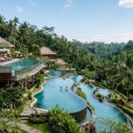 A wide view of a luxury hotel in Ubud with terraced pools and lush jungle.