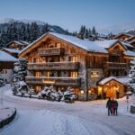 Best Hotels in Courchevel 1550: 2026 Stay Guide A charming hotel in Courchevel 1550 village, snow-covered at twilight.